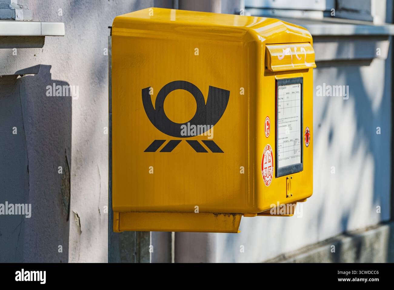Postfach der Deutschen Post in Markenfarben an der Seite einer Gebäudewand Stockfoto