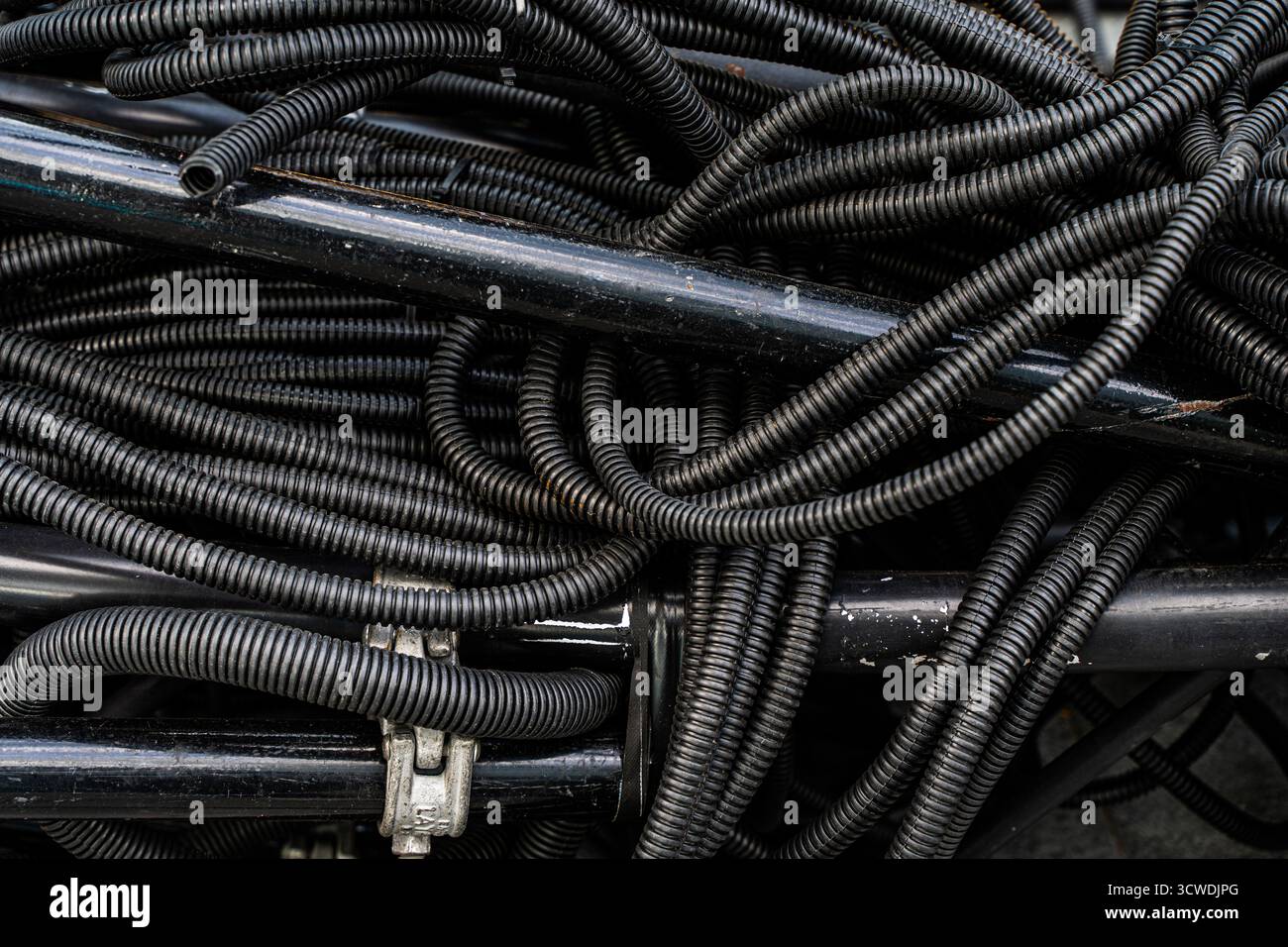 Hintergrund: Stapel von gebrauchten PVC-isolierten Elektrokabeln im Recyclingzentrum für Wertstoffe. Hochwertige photoelektrische Kabel, Hintergrund mit Blac Stockfoto