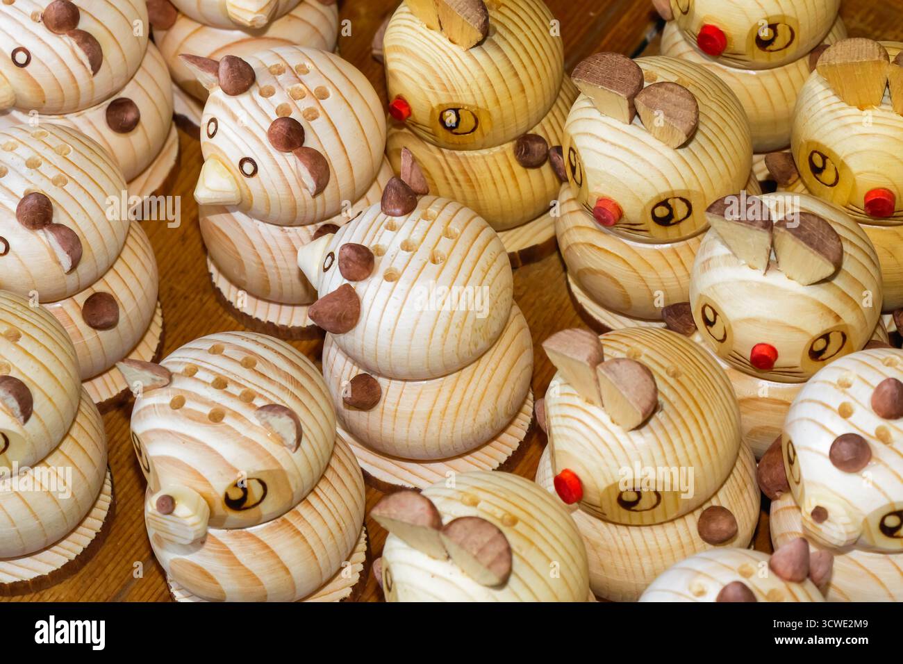 Nahaufnahme handgefertigter Tierfiguren aus hellem Kiefernholz mit geschnitzten Details und kleinen Akzenten, die die handwerkliche Kreativität repräsentieren Stockfoto