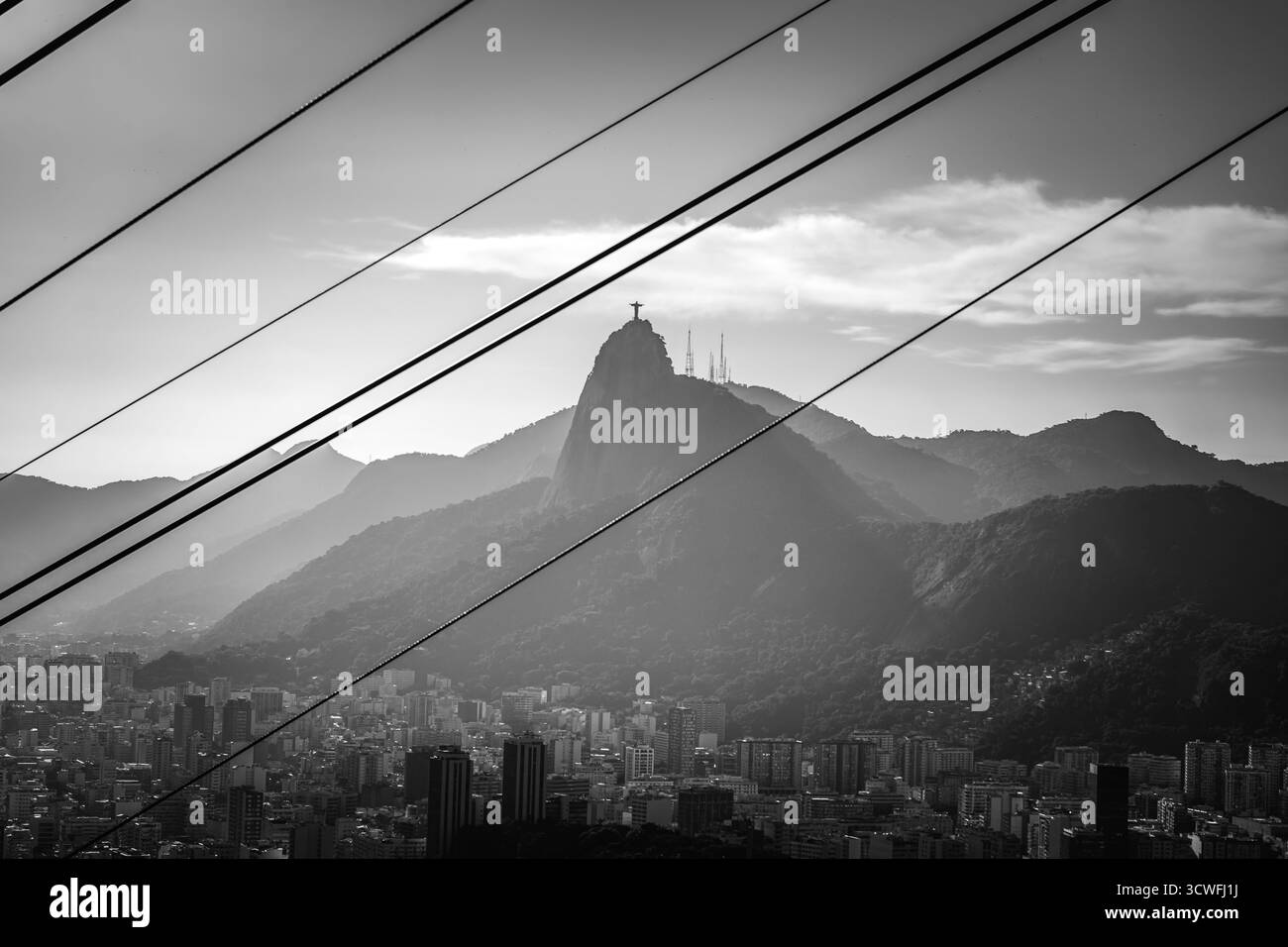 Schwarz-weiß Blick auf Christus, den Erlöser, eingerahmt von Cable Lines of the Sugarloaf - Rio de Janeiro, Brasilien Stockfoto