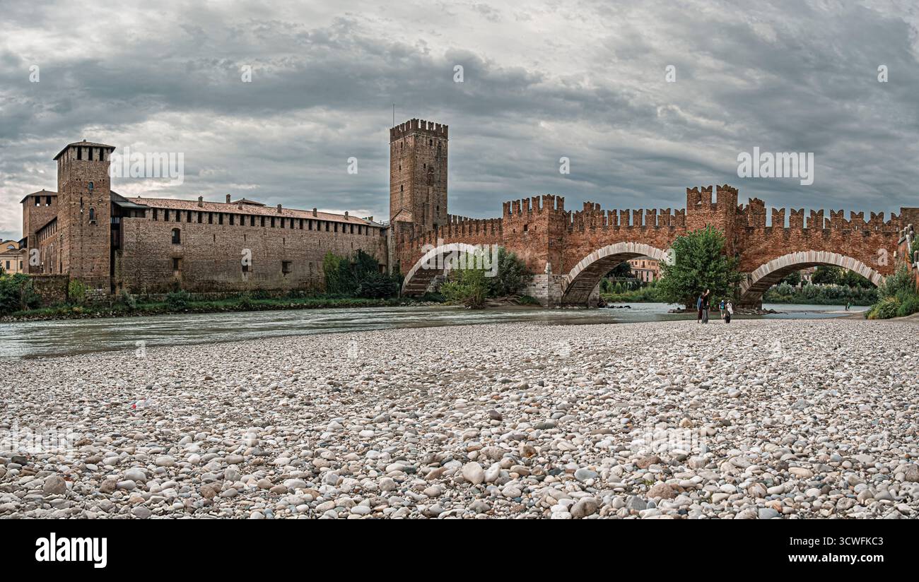 Das Schloss Scaliger von Castelvecchio und seine Brücke, von der Etsch aus gesehen an einem bewölkten Sommermorgen. Verona, Venetien, Italien. Stockfoto