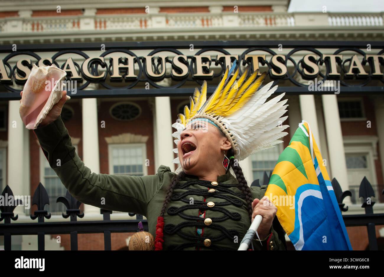 Boston, Massachusetts, USA. 11. Oktober 2025. März zum Tag der indigenen Völker. Chali'Naru Dones, Vereinigte Konföderation der Taino, am Tor des Haupteingangs zum Massachusetts State House am Boston. Die jährliche Demonstration seit 2016 unterstützt die Umstellung des US-Bundesfeiertags von Columbus auf den Tag der indigenen Völker. Der Columbus Day wird am zweiten Montag im Oktober gefeiert. Credit: Chuck Nacke / Alamy Live News Stockfoto