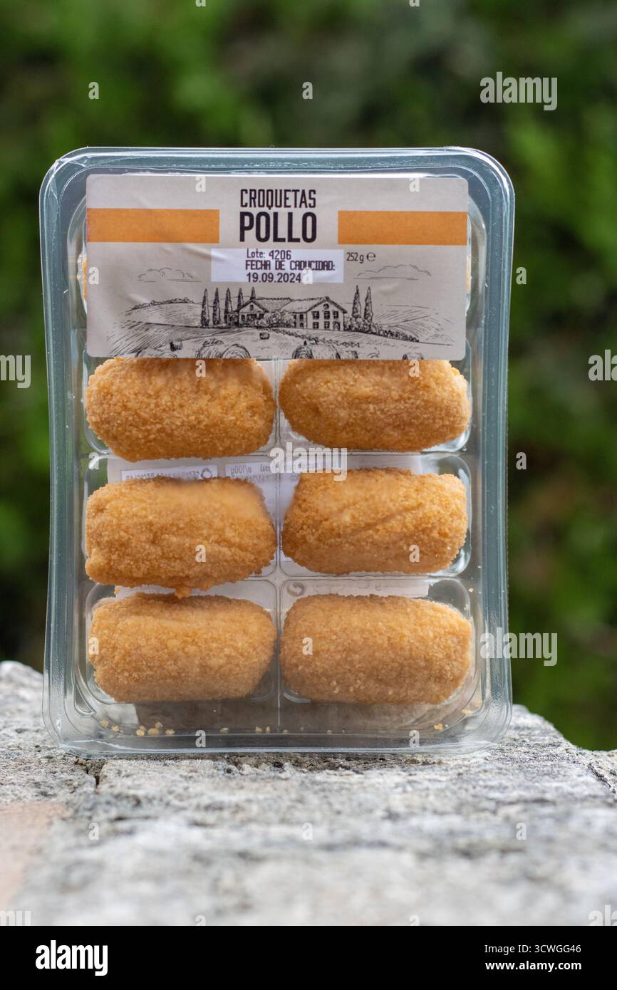 POLLENSA, MALLORCA, SPANIEN - 13. SEPTEMBER 2024 Kunststoffschale mit 8 Pollo-Kroketten Nahaufnahme isoliertes Produkt, das im Freien mit natürlichem Hintergrund entnommen wurde Stockfoto