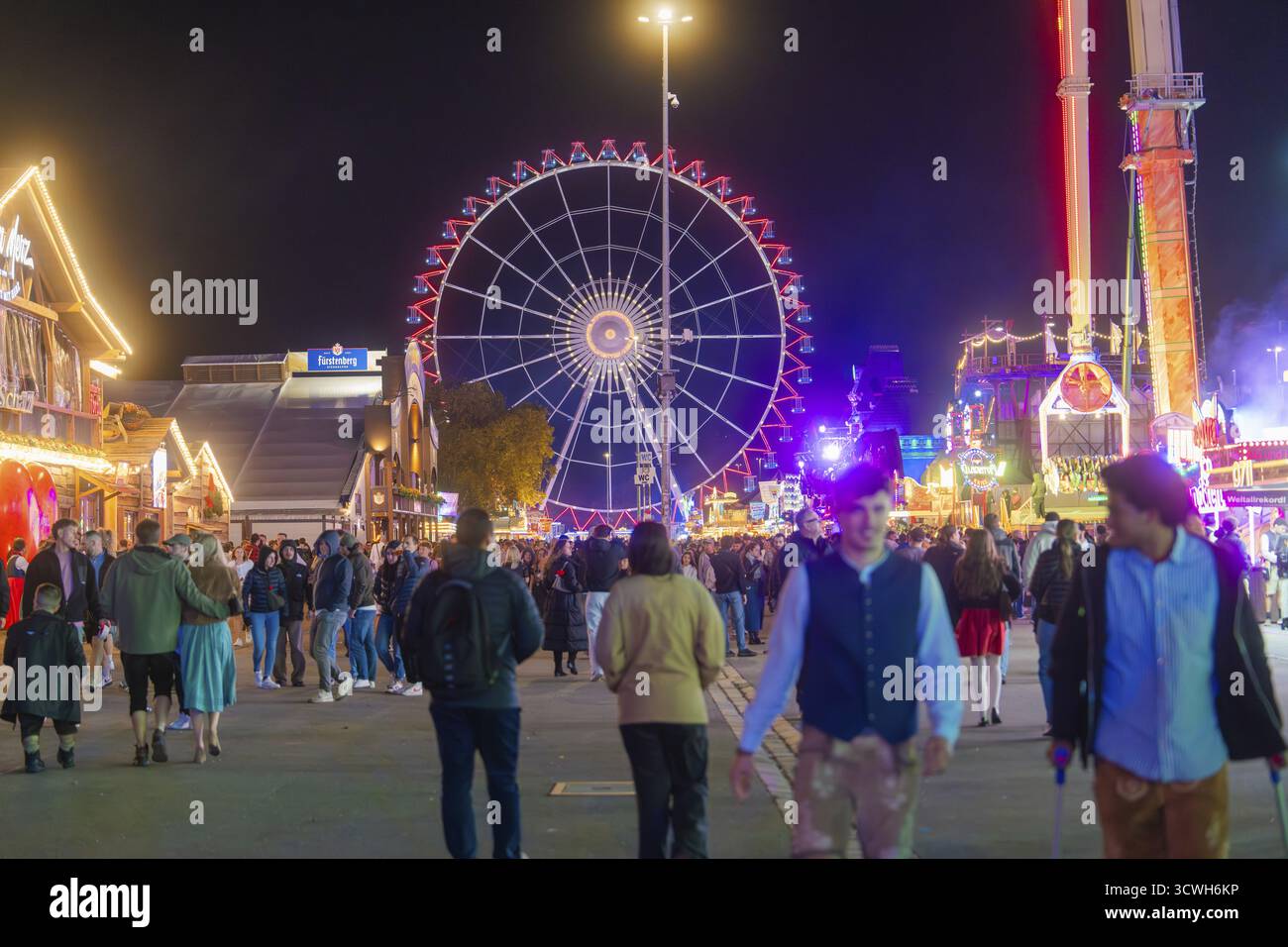 Nachtmarkt mit einem hell beleuchteten Riesenrad und vielen Besuchern, Cannstatter Wasen Messe, Stuttgart, Deutschland Stockfoto