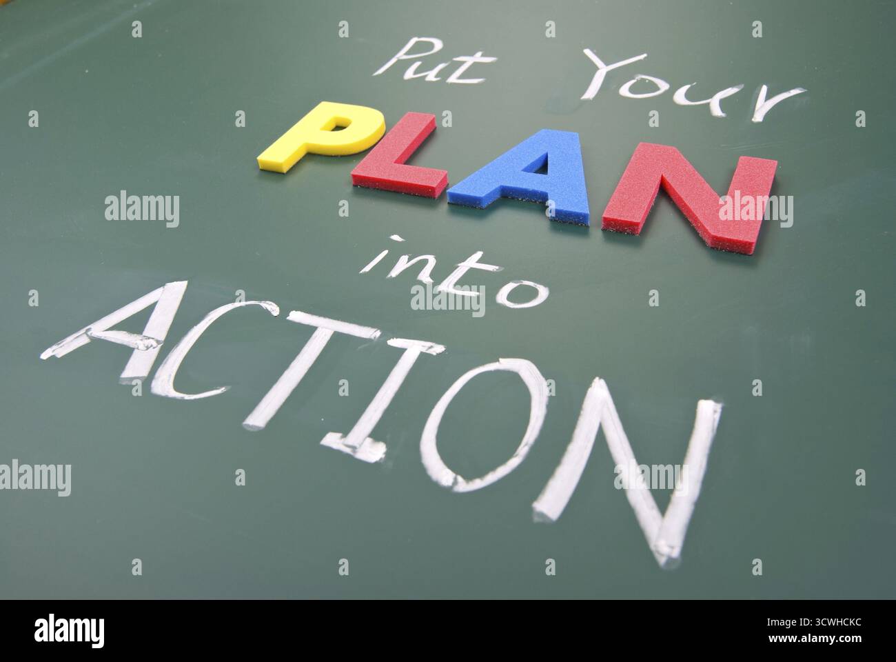 Setzen Sie Ihren Plan in die Tat um, Worte auf der Tafel Stockfoto