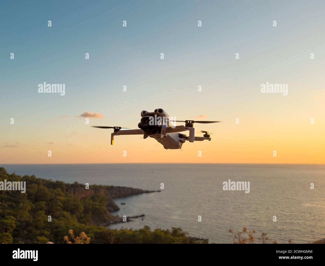 Antalya, Türkei - 11. Oktober 2025: Die neu erschienene DJI Mini 5 Pro Drohne fliegt durch einen goldenen Sonnenuntergang Stockfoto