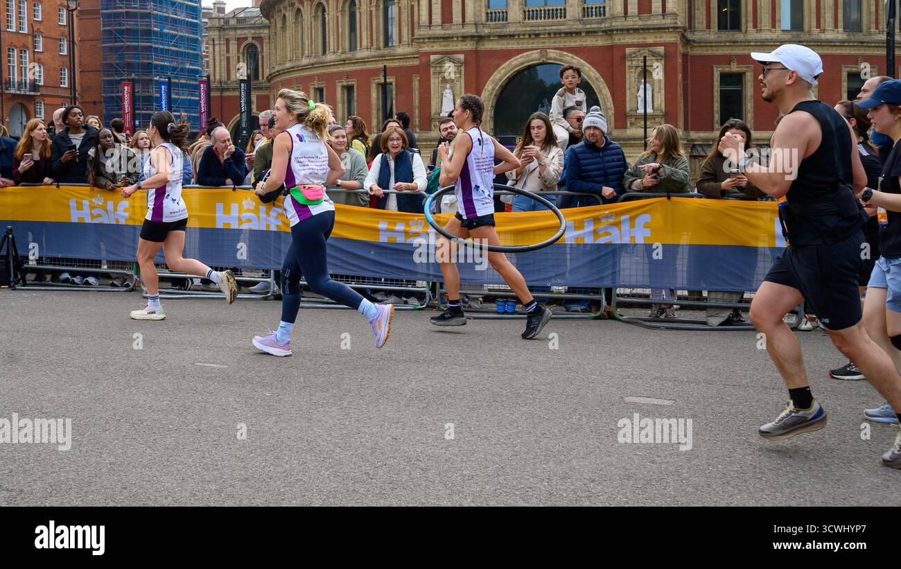 Tamara Ward Hula Hooping um den Royal Parks Half Marathon, um Geld für das Dravet Syndrom UK zu sammeln, eine Form der Epilepsie, die schon im Kindesalter beginnt. Dravet hat bereits in fünf Jahren 500.000 Pfund gesammelt. Das Rennen in und um Hyde Park, London, wurde von der Royal Parks Charity als jährliche Spendenaktion ins Leben gerufen. Seither hat die Veranstaltung über 70 Millionen Pfund für über 1.200 britische Wohltätigkeitsorganisationen eingebracht Stockfoto