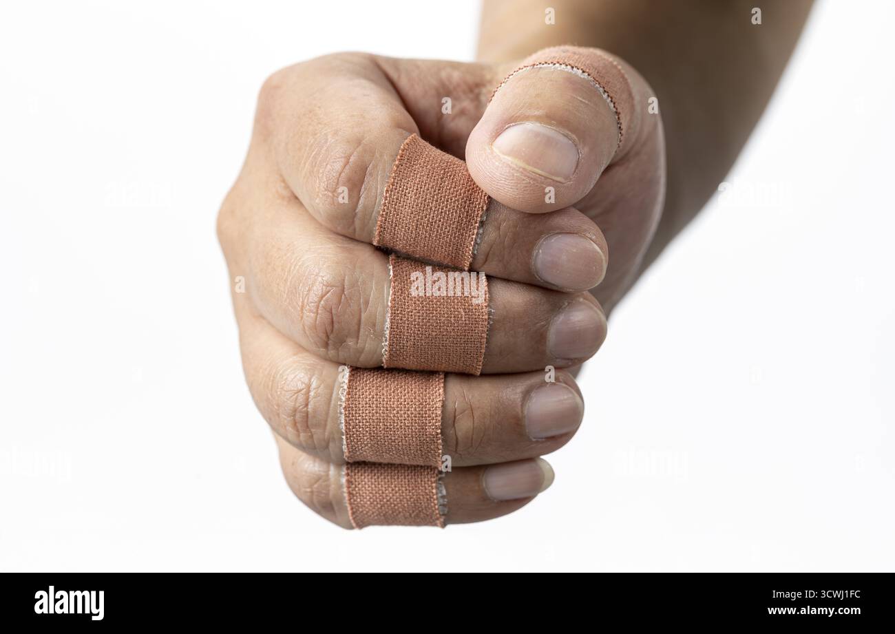 Gezeigt wird eine Faust mit Fingerbandagen, die ein Gefühl von Belastbarkeit und Heilung vermittelt. Bandagen sind um die Finger gewickelt Stockfoto