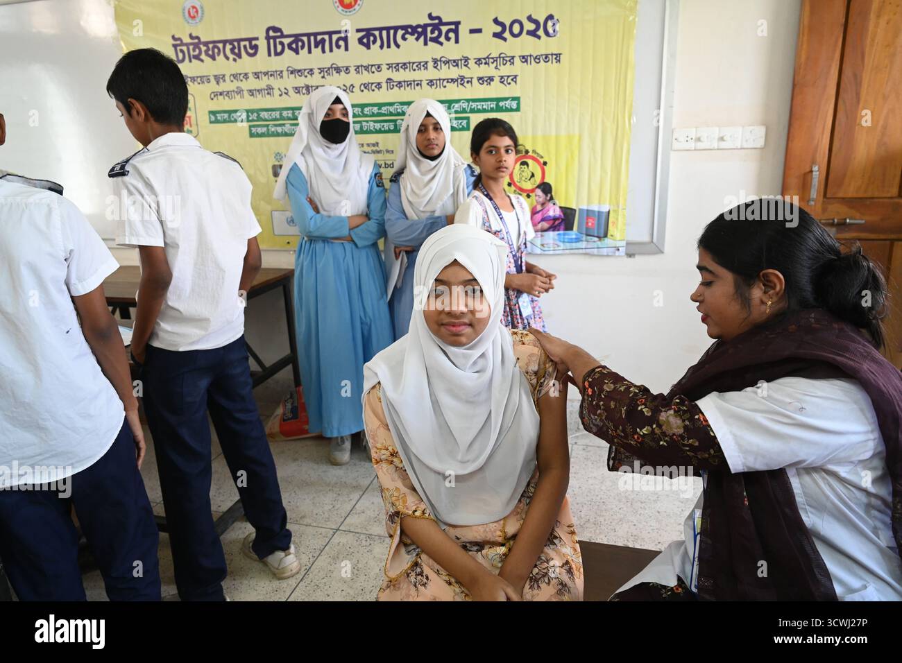 Ein Schüler erhält während einer nationalen Impfkampagne in Dhaka, Bangladesch, am 12. Oktober 2025 einen Typhus-Impfstoff in einem Schulimpfzentrum. Zum ersten Mal hat die Regierung damit begonnen, Typhus im ganzen Land zu impfen. Etwa 50 Millionen Kinder im Alter von 9 Monaten bis 15 Jahren erhalten den Impfstoff über 18 Arbeitstage kostenlos. Die ersten 10 Arbeitstage werden in verschiedenen Schulen und die nächsten acht Arbeitstage in Impfzentren gegeben. Stockfoto