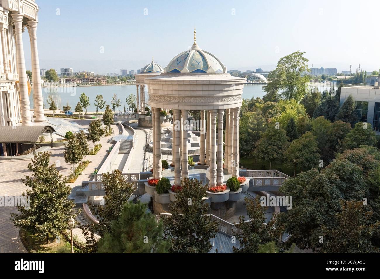 Majestätischer Blick auf den Navruz-Palast in Duschanbe, Tadschikistan, mit großen Säulen, Kuppelpavillons und einer malerischen Seenlandschaft unter einem klaren blauen Stockfoto