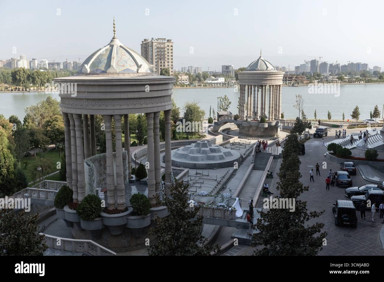 Majestätischer Blick auf den Navruz-Palast in Duschanbe, Tadschikistan, mit großen Säulen, Kuppelpavillons und einer malerischen Seenlandschaft unter einem klaren blauen Stockfoto