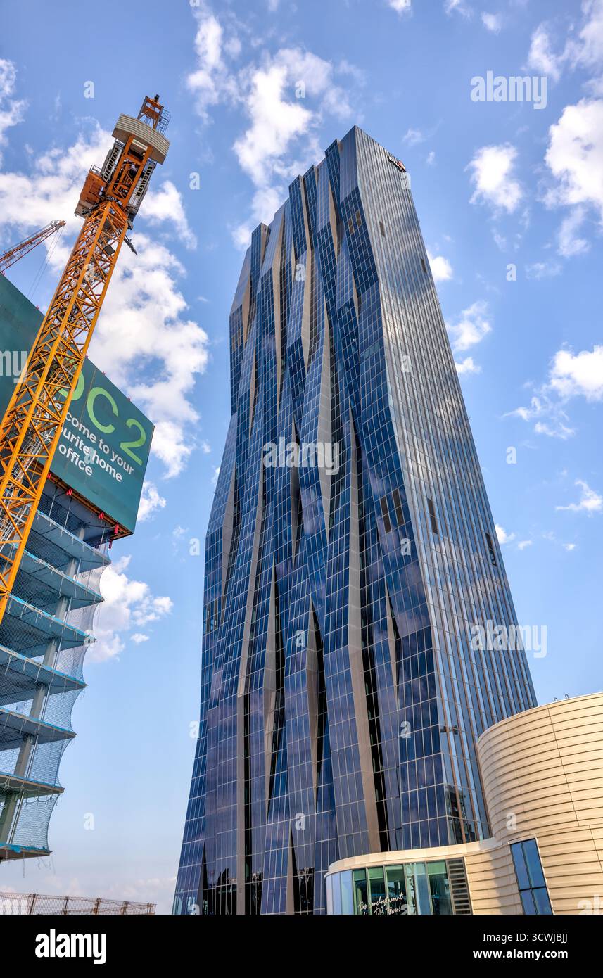Der Wolkenkratzer DC Tower 1 in Donau City reflektiert das Abendsonnenlicht über der Donau, ein Wahrzeichen des modernen Wien. Stockfoto