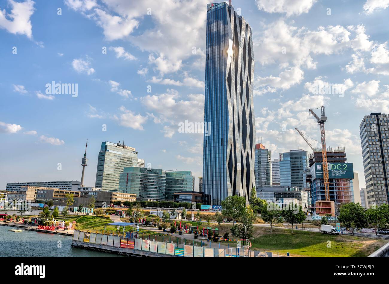 Der Wolkenkratzer DC Tower 1 in Donau City reflektiert das Abendsonnenlicht über der Donau, ein Wahrzeichen des modernen Wien. Stockfoto