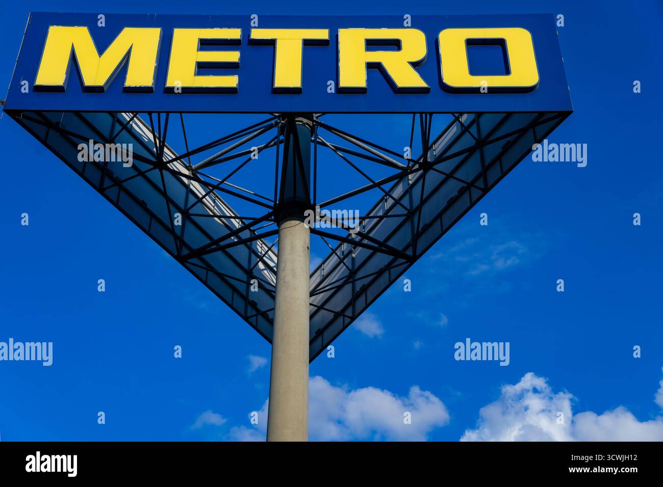 Metro Großhandelsgeschäft Schild mit gelbem Logo auf blauem Himmel Hintergrund in Berlin, Deutschland, an einem hellen sonnigen Tag Stockfoto