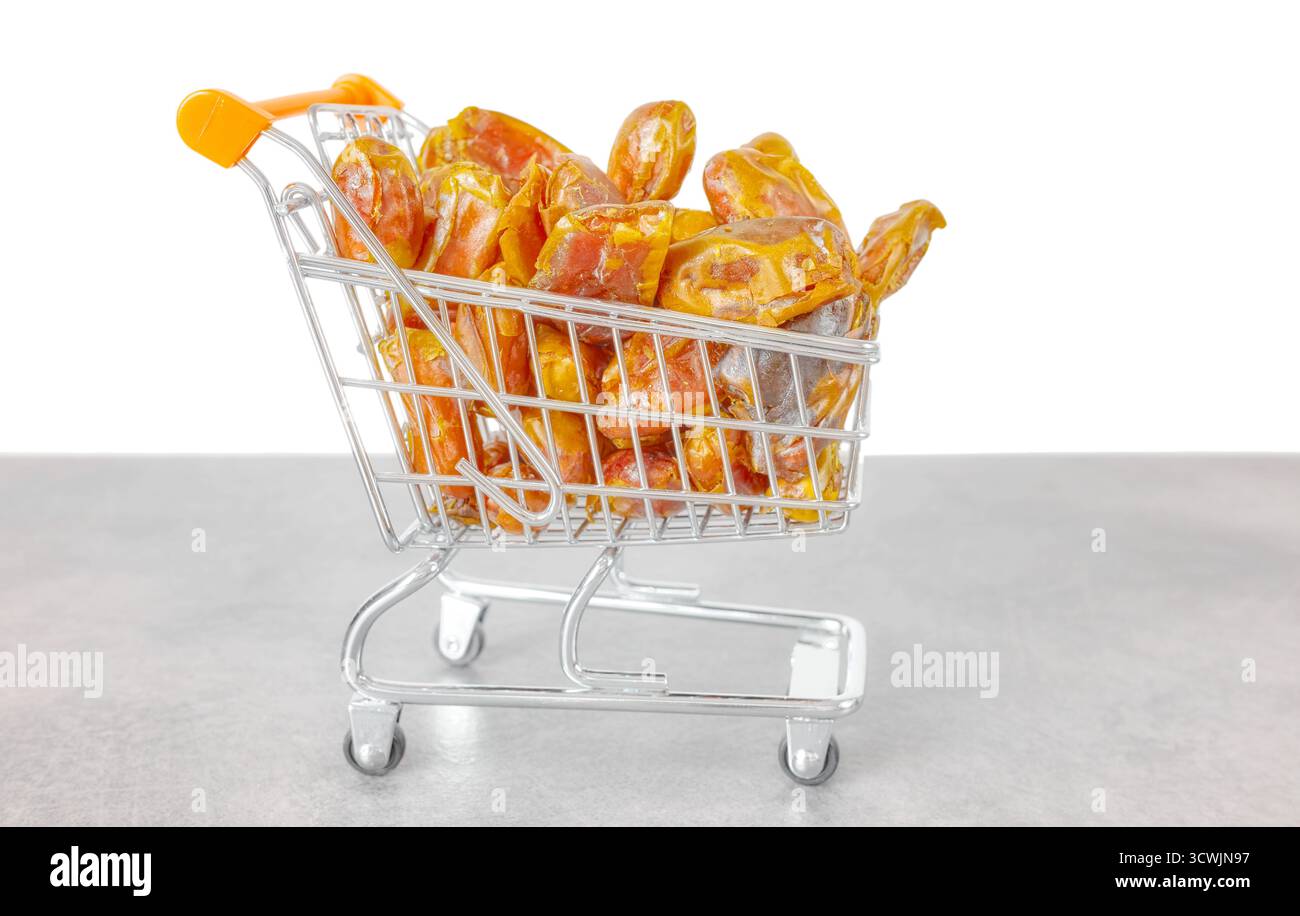 Getrocknete Datteln in einem Miniatur-Einkaufswagen, selektiver Fokus. Stockfoto