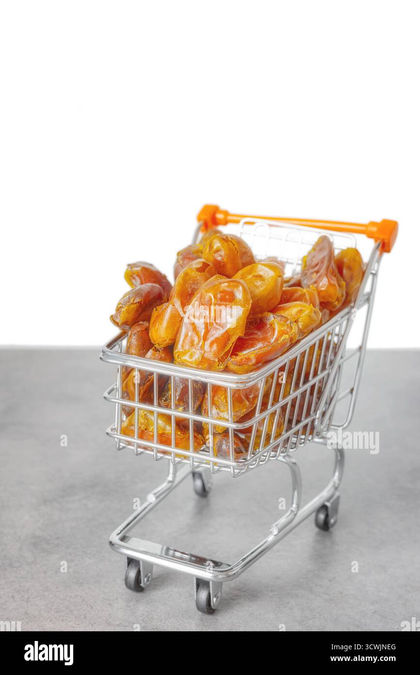 Getrocknete Datteln in einem Miniatur-Einkaufswagen, selektiver Fokus. Stockfoto