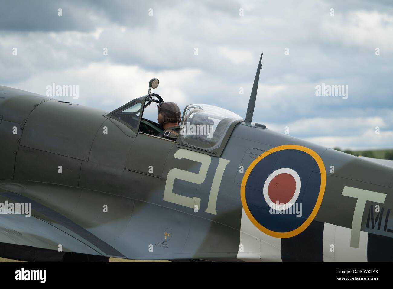 Pilot im Cockpit eines restaurierten Spitfire-Kampfflugzeugs mit RAF-Roundel-Markierungen Stockfoto