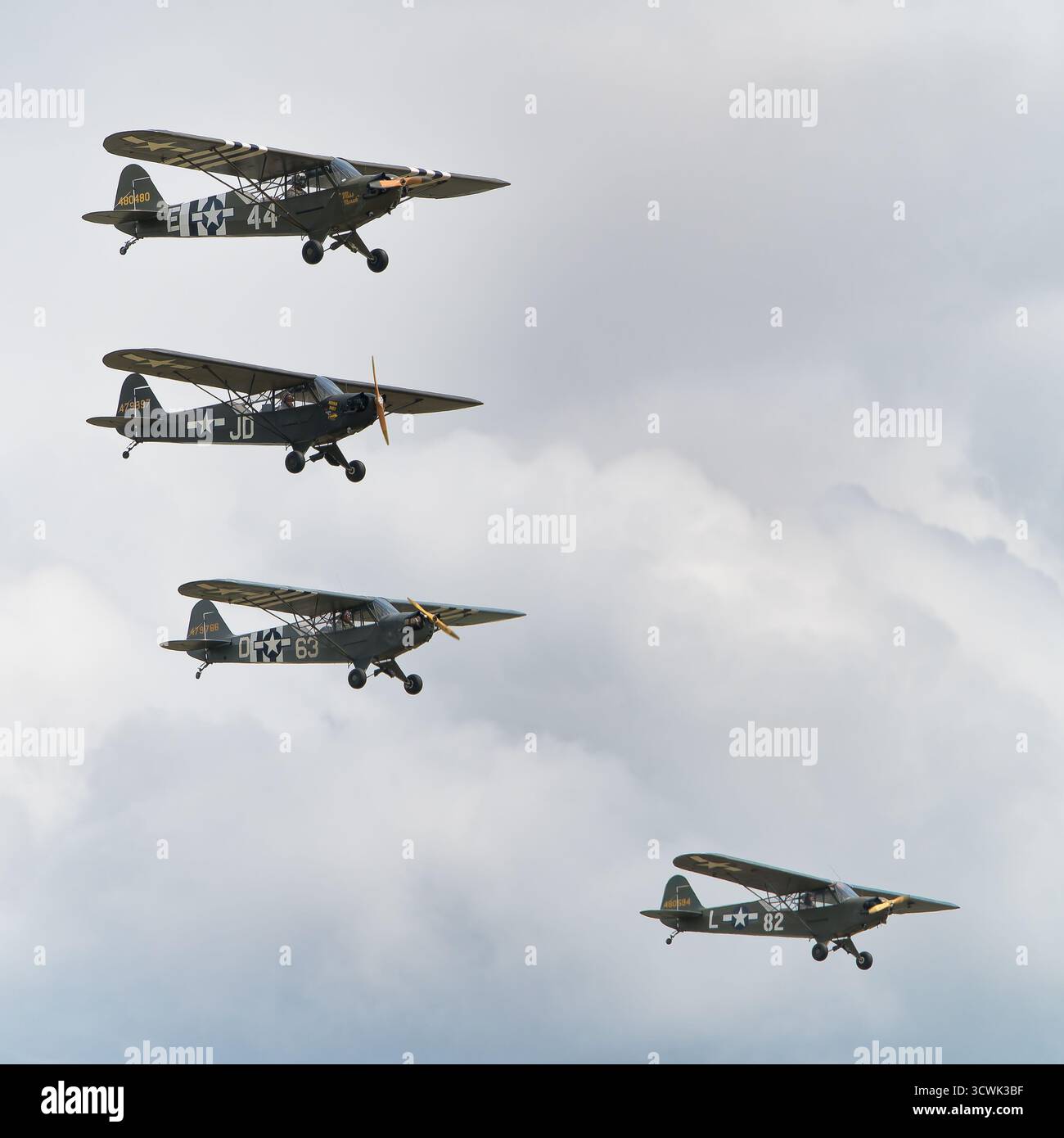 Vier Oldtimer-Militärflugzeuge im Formationsflug gegen bewölkten Himmel in Duxford Stockfoto