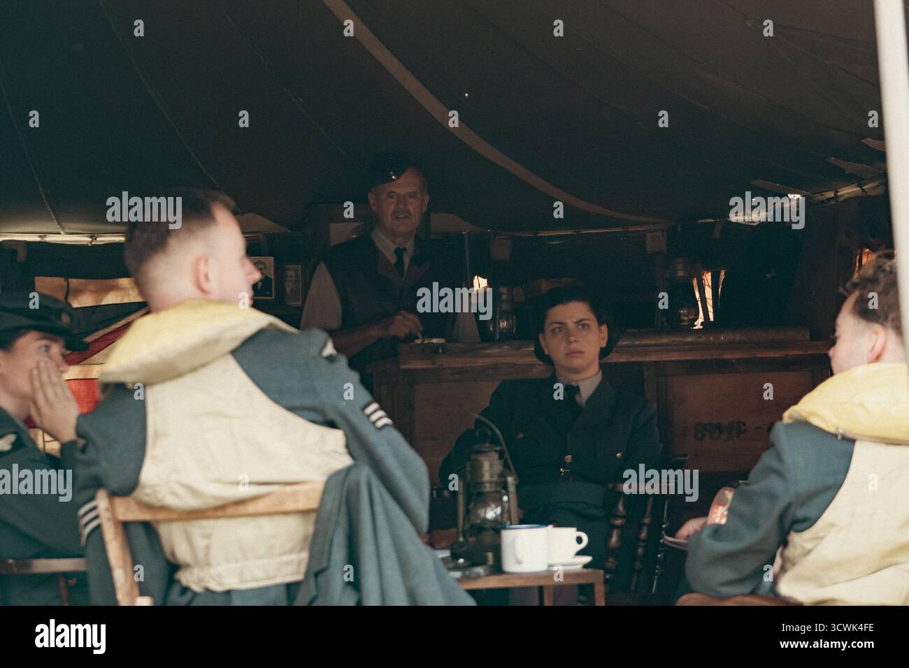 RAF-Flugzeugbesatzung in zeitlicher Uniform, die sich in der Kabine eines Oldtimer-Flugzeugs entspannt Stockfoto