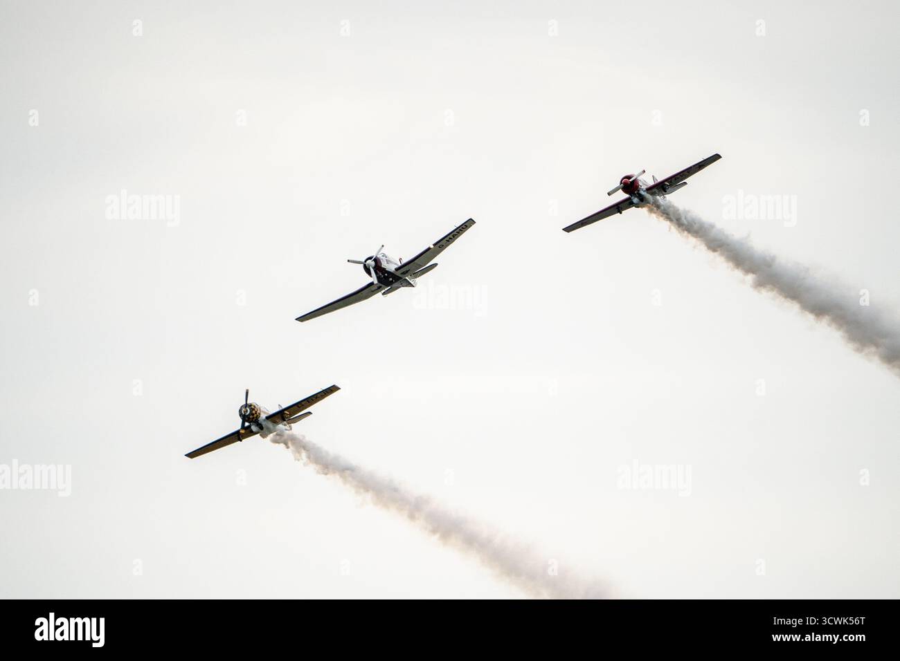 Drei Oldtimer-Flugzeuge in Formation mit Rauchspuren auf der Duxford Air Show Stockfoto