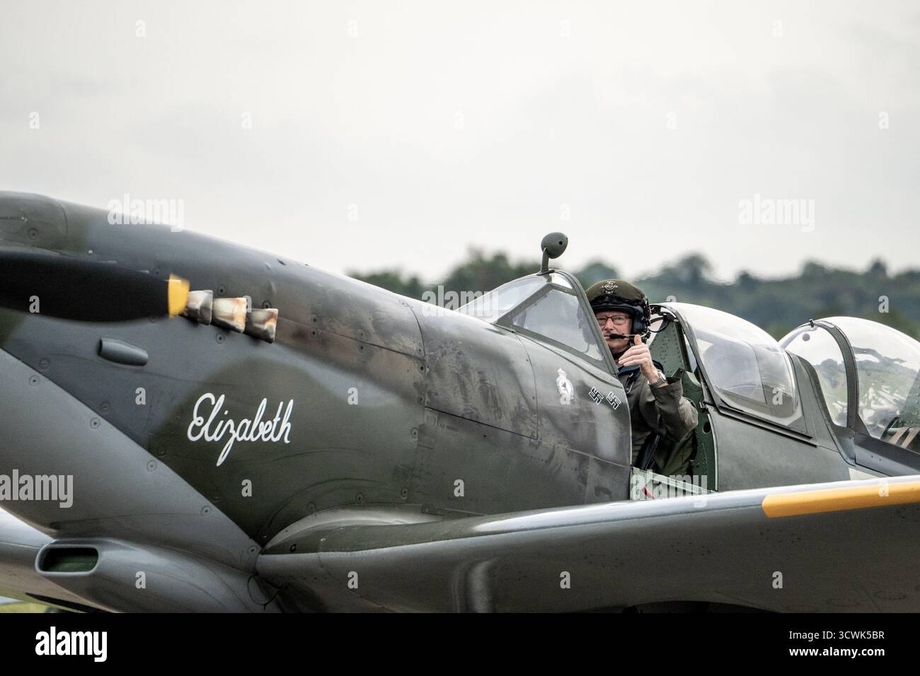 Pilot im Cockpit eines alten Spitfire-Flugzeugs namens Elizabeth auf dem Flugplatz Duxford Stockfoto