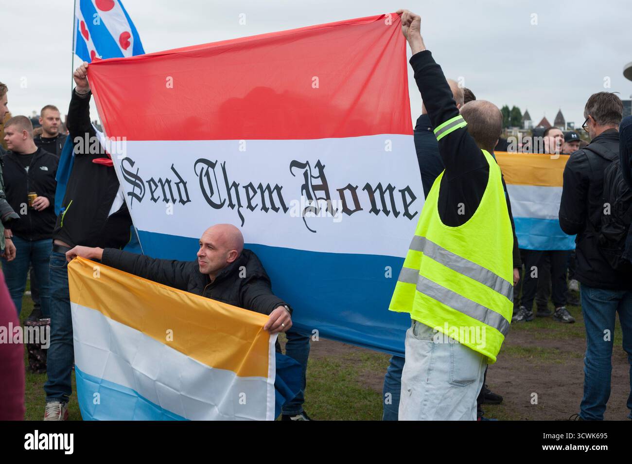 Amsterdam, Museumplein - 12. Oktober 2025: "Anti-Immigrations-Protest, Nationaal-Protest, Text: "Schicken Sie sie nach Hause" niederländische Flagge, Prinsenvlag, Stockfoto