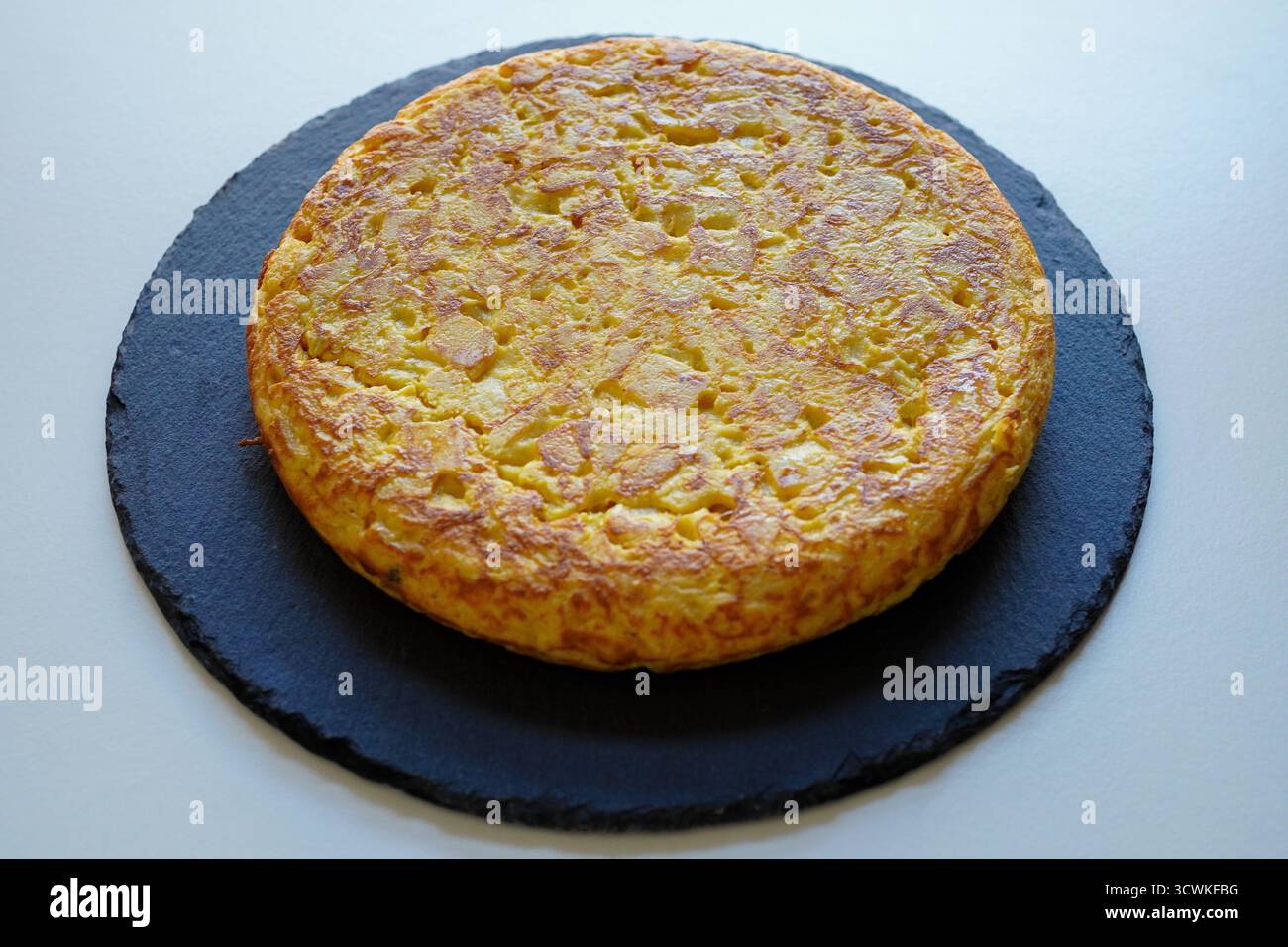 Hausgemachtes spanisches Omelett (Tortilla de patatas) auf weißem Hintergrund Stockfoto