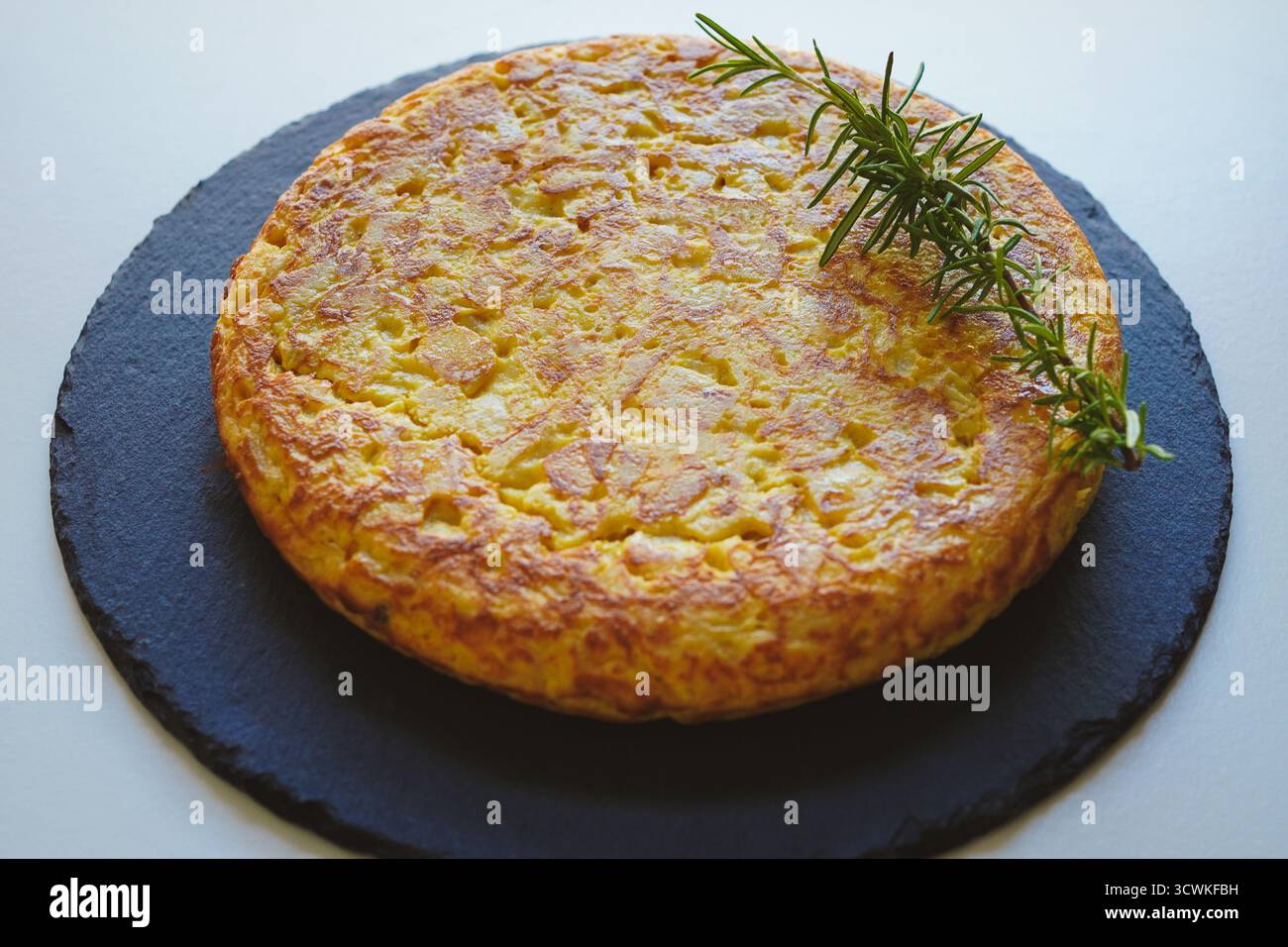Hausgemachtes spanisches Omelett (Tortilla de patatas) auf weißem Hintergrund Stockfoto