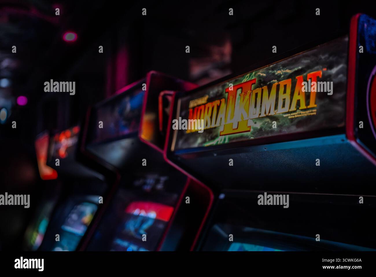 Das Mortal Kombat II Arcade Cabinet Zelt leuchtet in Neonlichtern in einem Retro-Spielezentrum Stockfoto