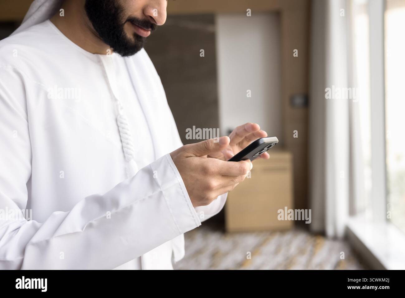 Nahaufnahme junger arabischer Männer in traditioneller islamischer Kleidung mit Telefon Stockfoto