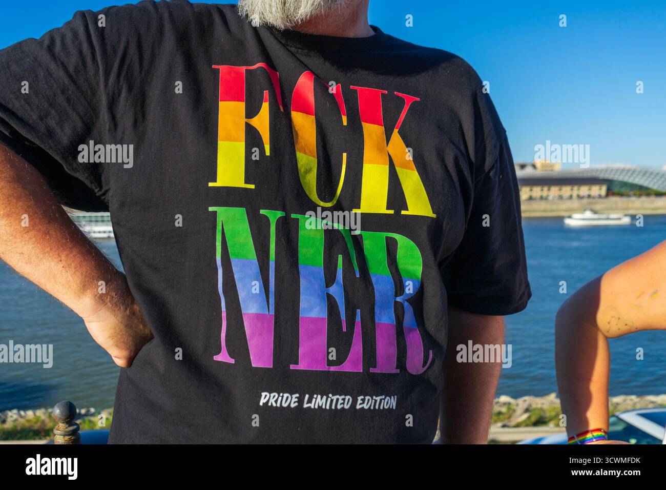 Ein Mann trägt während des Budapest Pride 2025 ein Hemd im Regenbogenmotiv mit der Aufschrift „FCK NER“ und drückt damit Widerstand gegen das ungarische Regierungssystem aus. Stockfoto