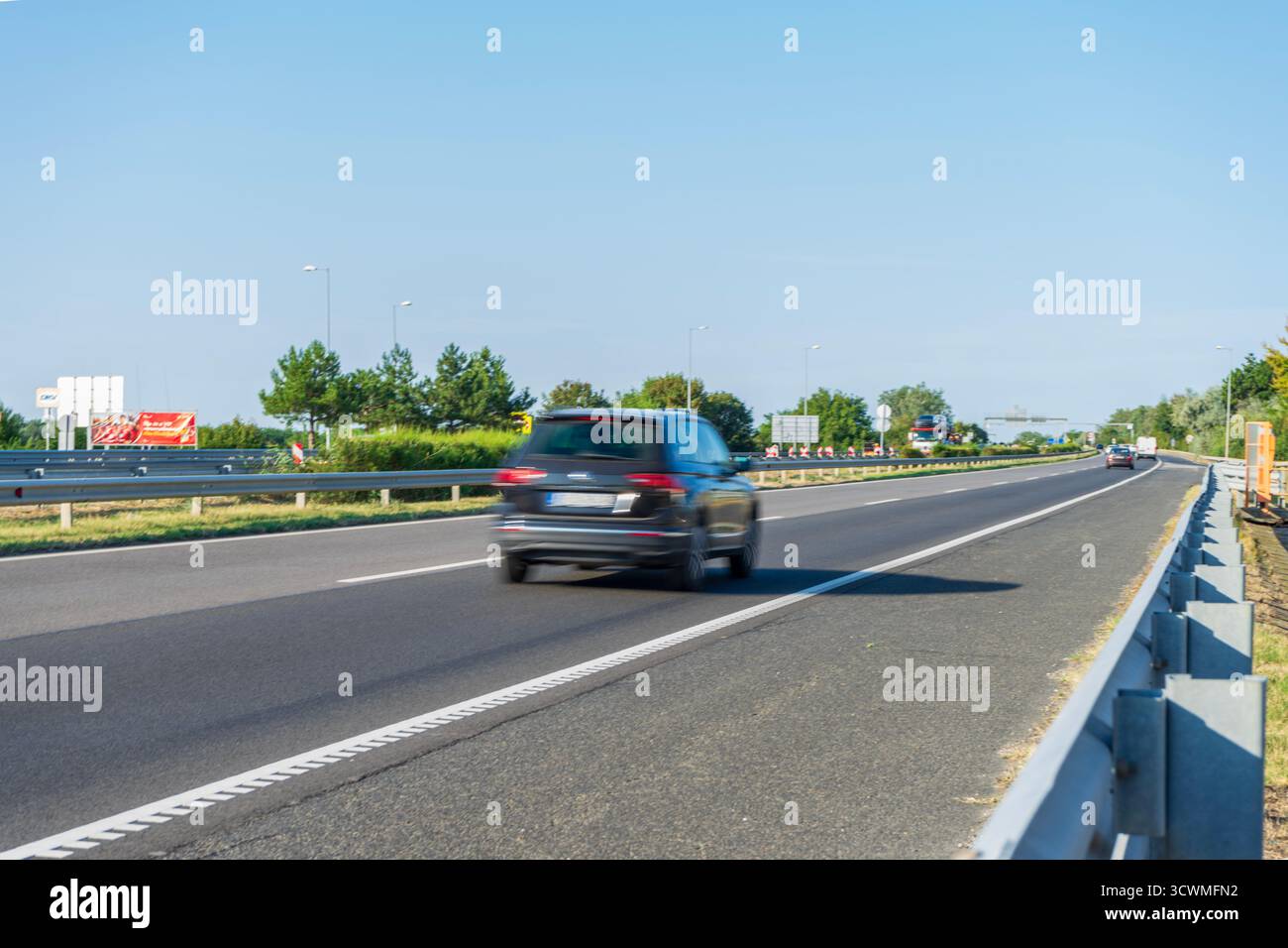 Der Verkehr auf der Autobahn M7 in der Nähe von Budapest beschleunigt an einem klaren Sommertag, was Ungarns wichtigste westliche Route veranschaulicht. Stockfoto