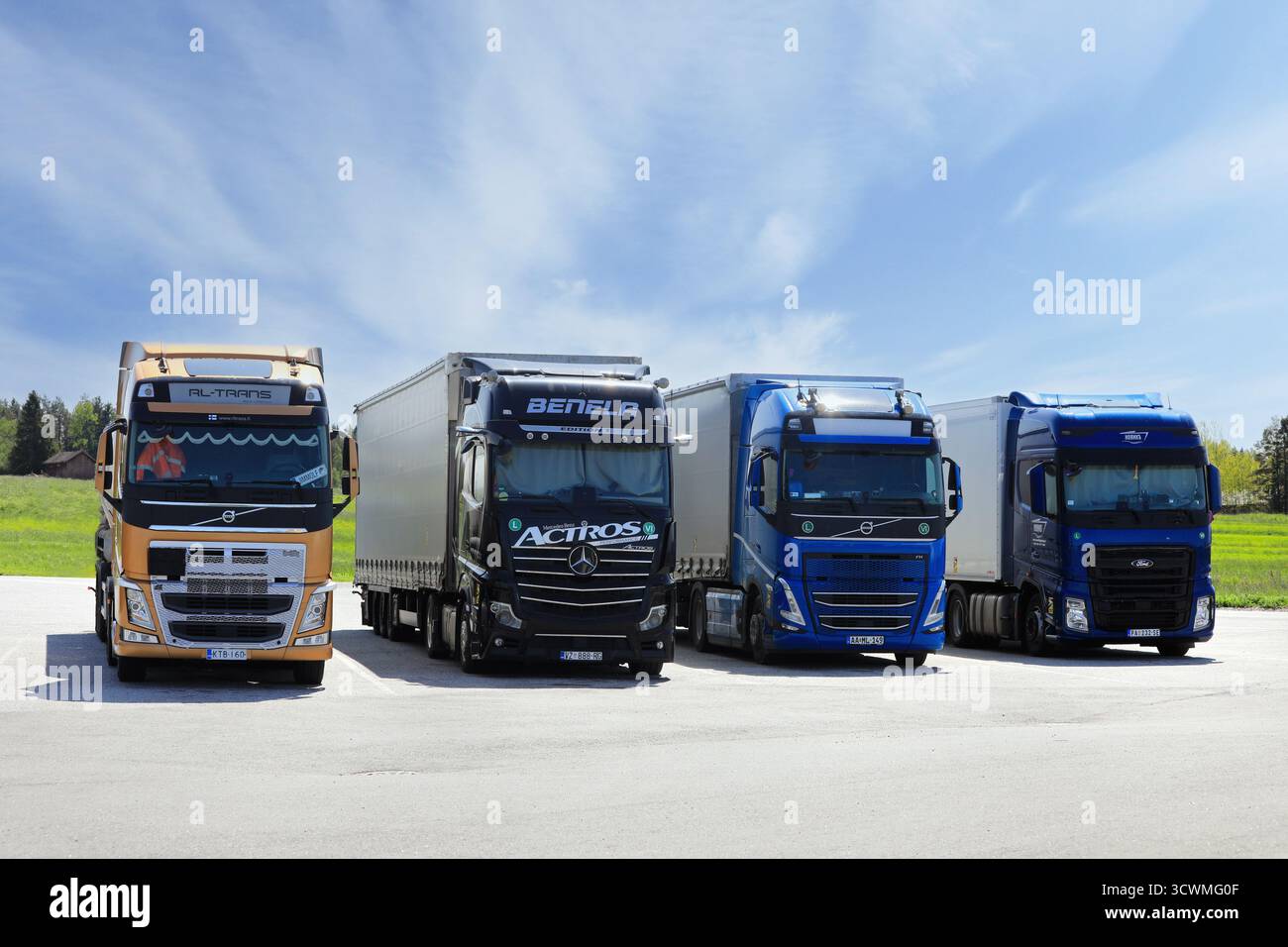 Internationale Schwerlastfahrzeuge Volvo FH, Mercedes-Benz Actros und Ford F-Max für den Güterverkehr, die an der LKW-Haltestelle abgestellt werden. Salo, Finnland. Juni 2025. Stockfoto