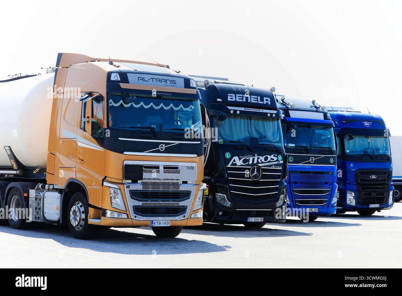 Internationale Schwerlastfahrzeuge Volvo FH, Mercedes-Benz Actros und Ford F-Max für den Güterverkehr, die an der LKW-Haltestelle abgestellt werden. Salo, Finnland. Juni 2025. Stockfoto
