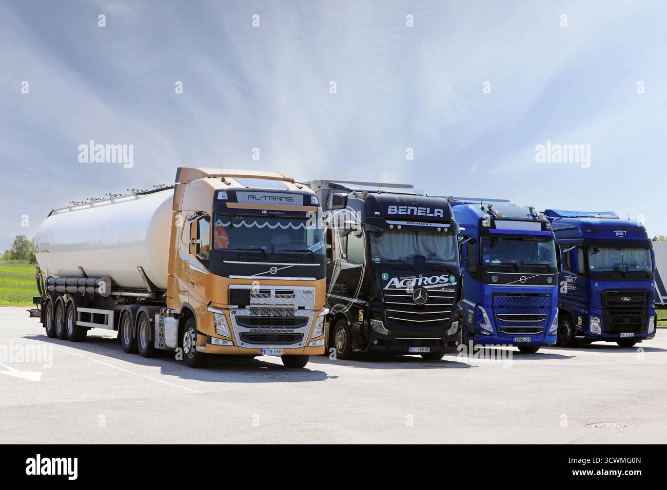 Internationale Schwerlastfahrzeuge Volvo FH, Mercedes-Benz Actros und Ford F-Max für den Güterverkehr, die an der LKW-Haltestelle abgestellt werden. Salo, Finnland. Juni 2025. Stockfoto