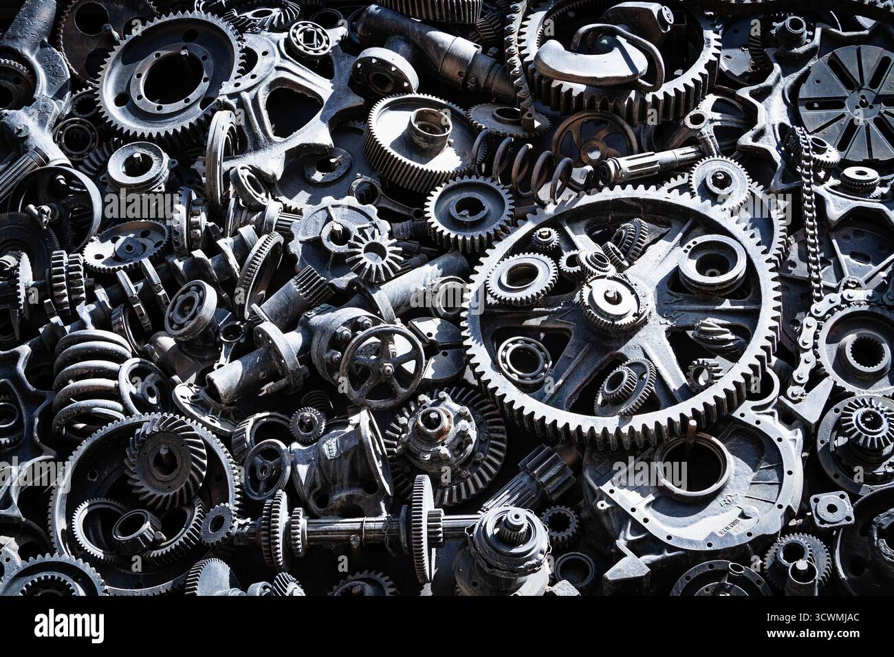Hintergrund Metallgetriebe. Alte und rostige Ersatzteile für Industriemaschinen auf Deponien. Stockfoto
