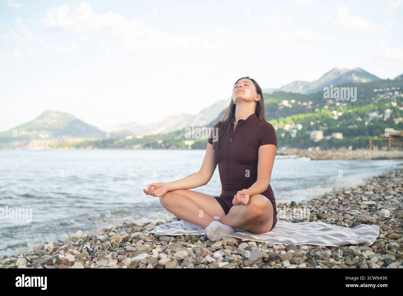 Junge Frau, die Yoga an der Küste übt, Outdoor-Fitness und aktiven Lebensstil genießt frische Luft Stockfoto