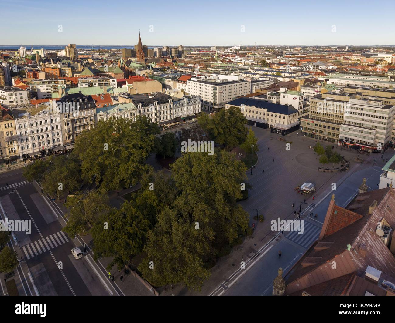 Aus der Vogelperspektive auf den pulsierenden Gustav Adolf Torg Platz mit seinen üppigen grünen Bäumen, die sich von den umliegenden Gebäuden abheben, eine fesselnde Mischung aus n Stockfoto