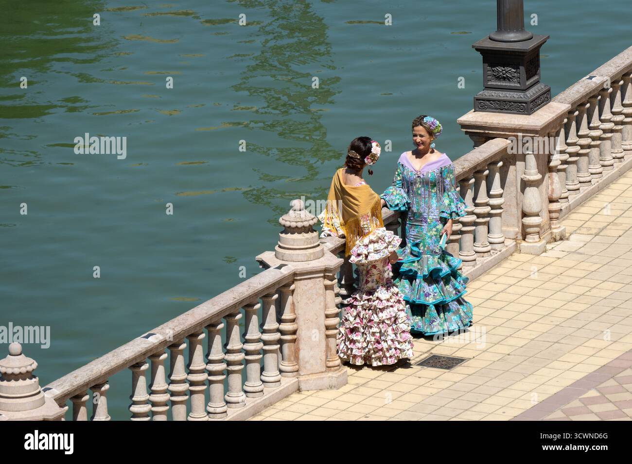 Sevilla, Spanien - 23. April: Zwei Frauen in traditionellen bunten Kleidern stehen am Ufer Stockfoto