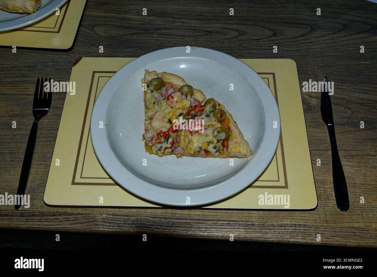 Eine Margherita Pizza-Basis mit zusätzlichen Zutaten – zwei Scheiben, die nach dem Kochen serviert werden können. Stockfoto