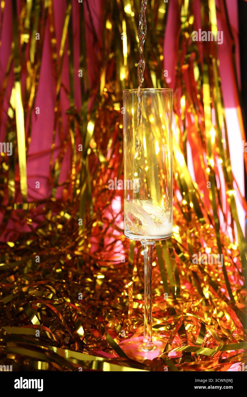 Champagner wird in moderne Glasflöte für einen Toast gegossen Stockfoto