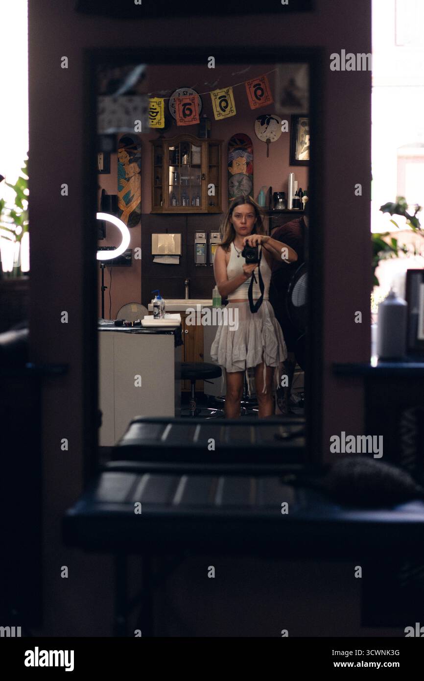 Porträt einer Frau, die eine Kamera in einem Tätowierstudio hält Stockfoto