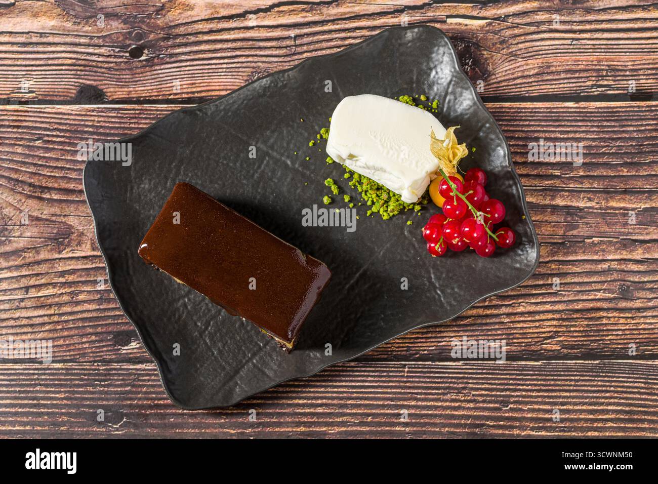Kräftiger Schokoladenbrownie mit Vanilleeis und Beeren Stockfoto