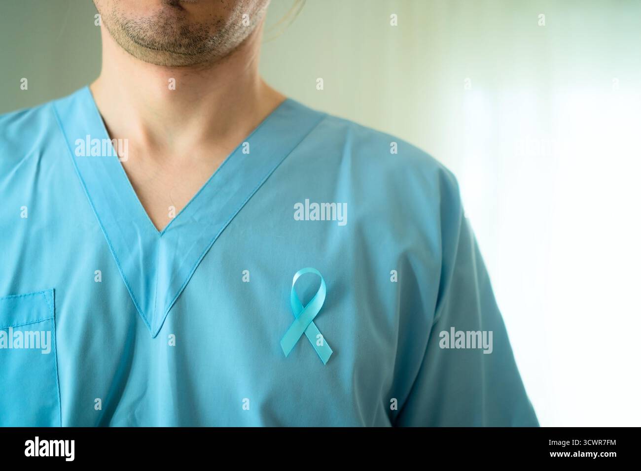Arzt in medizinischer Kleidung mit blauem Band auf der Brust symbolisiert November Prostatakrebs Bewusstsein und Früherkennung für rechtzeitige medizinische Versorgung. Stockfoto