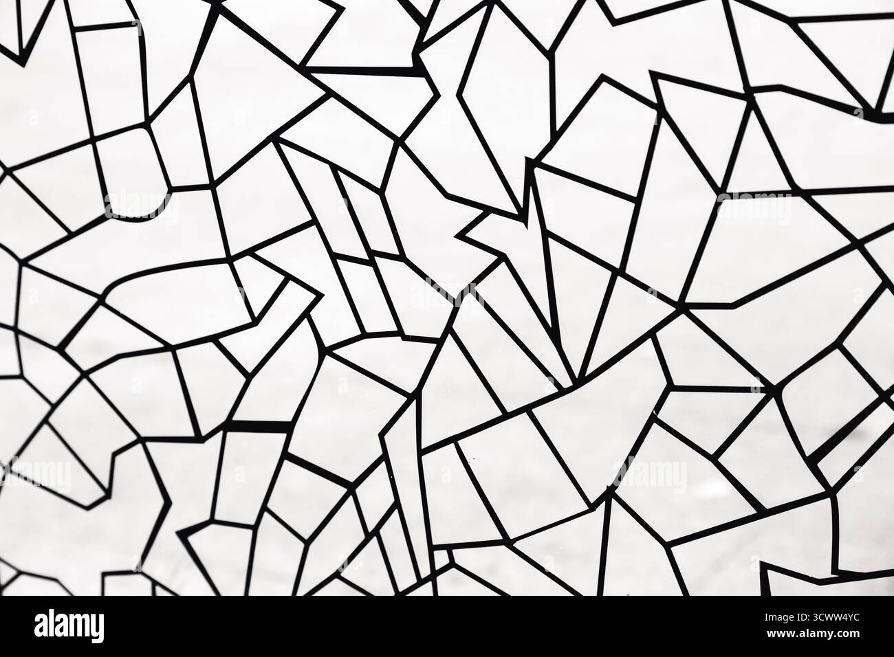 Schwarze polygonale Muster in Form von Linien unterschiedlicher geometrischer Formen auf weißem Glas Stockfoto