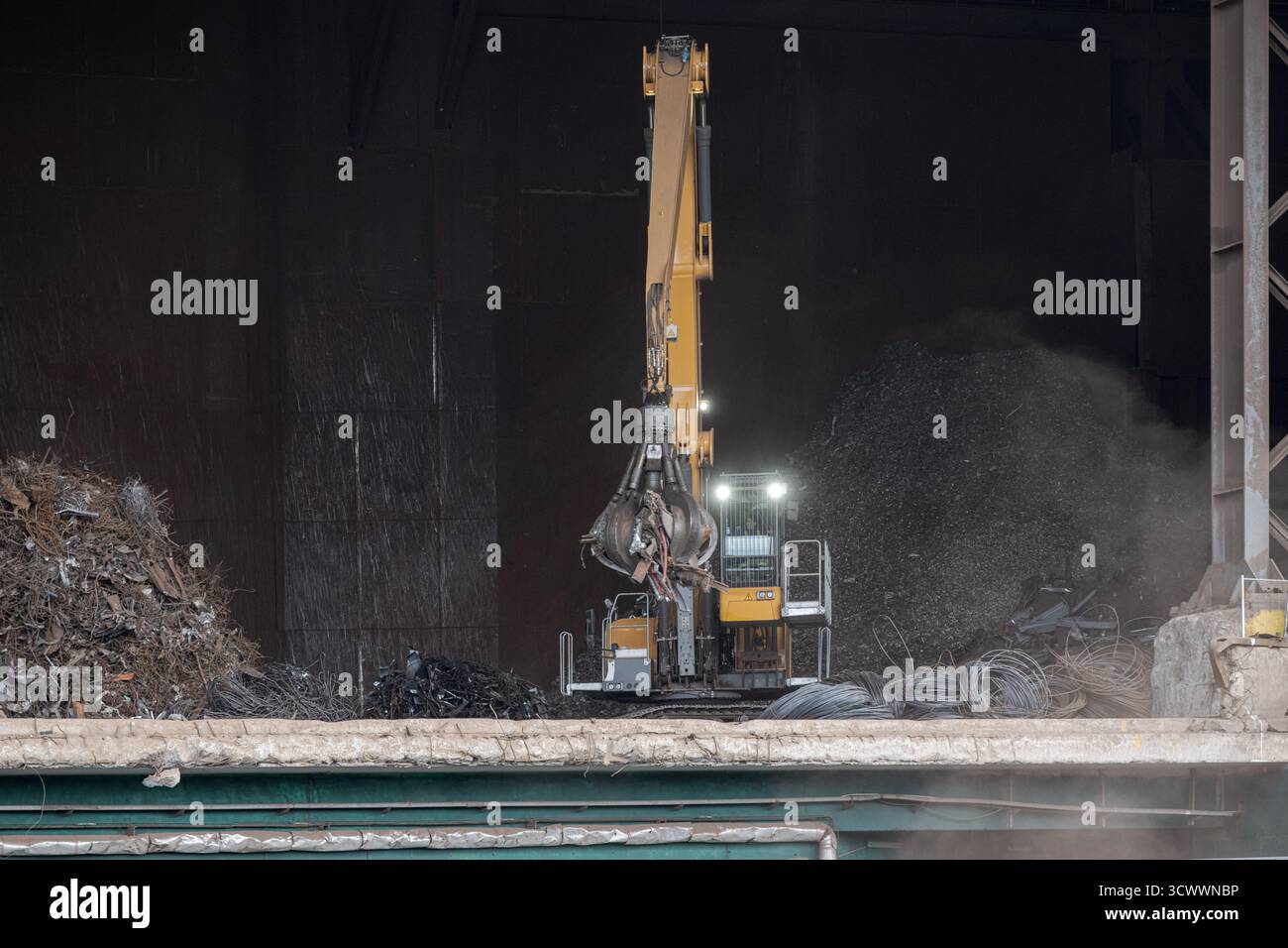 Bagger mit hydraulischer Klaue zum Verladen von Schrott in Recyclinganlagen – Industriemaschinen und Nachhaltigkeitskonzept Stockfoto