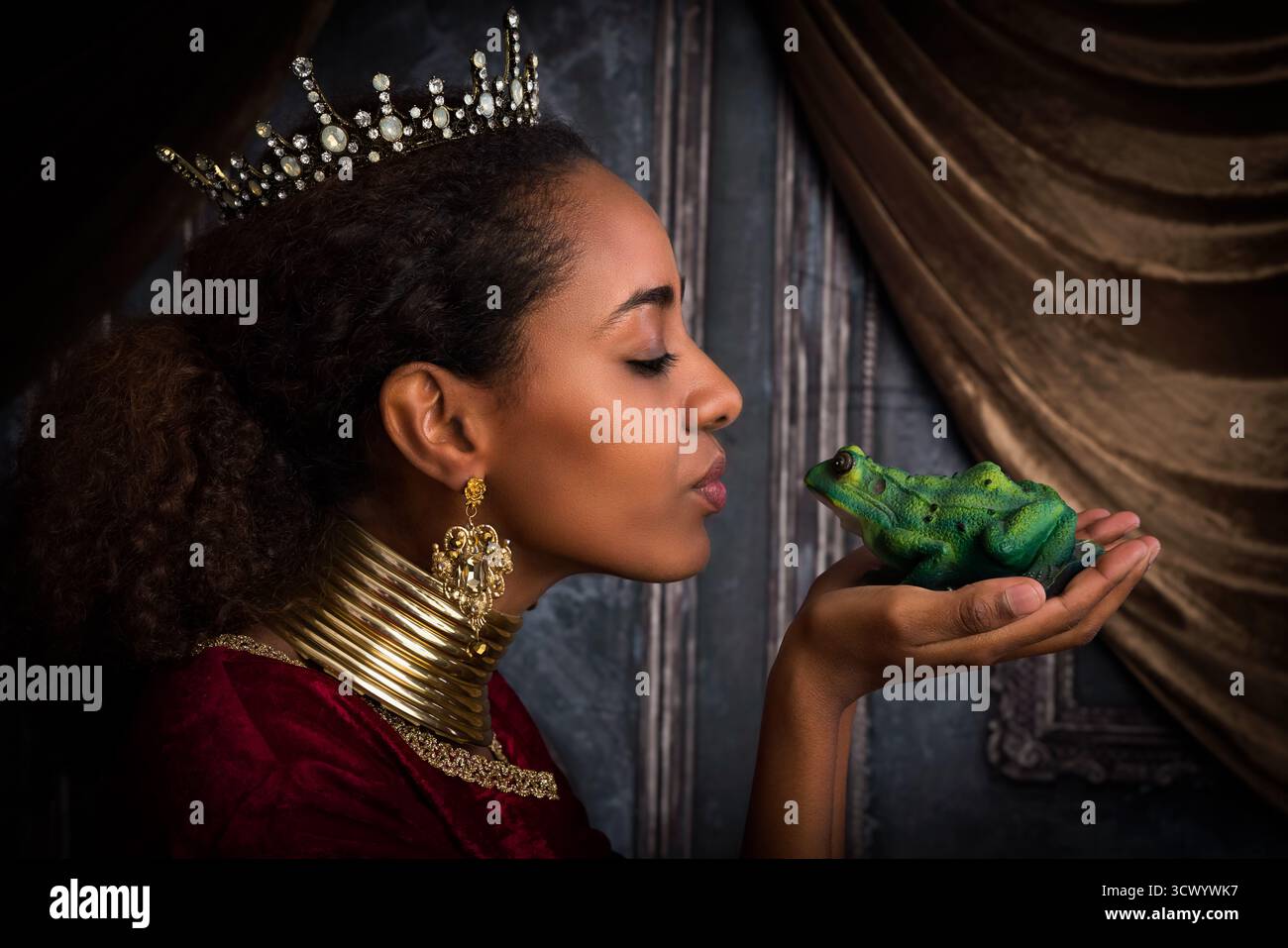 Die wunderschöne afrikanische Prinzessin küsst einen grünen Baumfroschprinzen Stockfoto