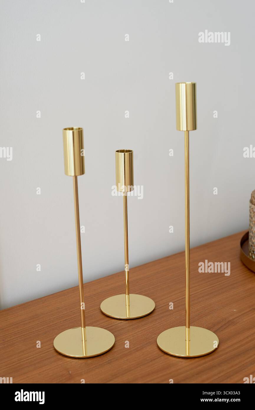 Goldene Kerzenhalter unterschiedlicher Höhe ohne Kerzen. Minimalistischer Stil, Stockfoto