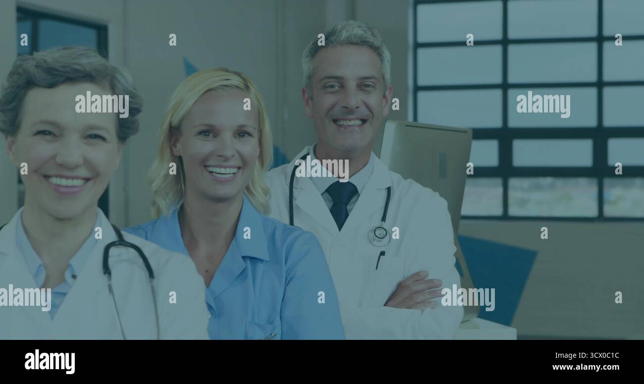 Group of three medical staff standing in hospital corridor, with stethoscopes and cardboard boxes Stockfoto