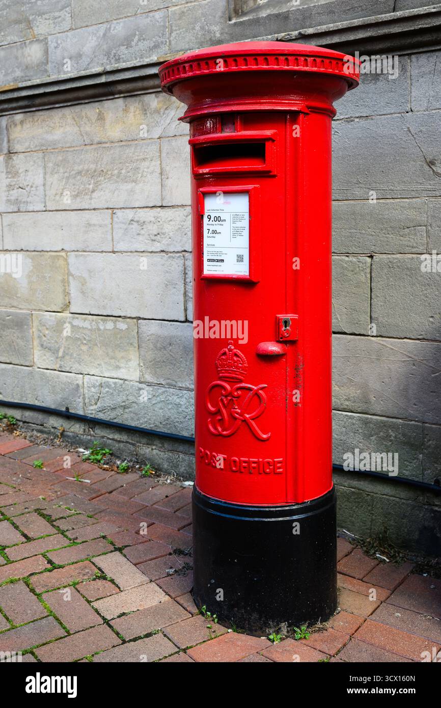 Oswestry, England, Großbritannien - 29. August 2025; königliche Chiffre von George VI. Auf rotem Briefkasten auf der Backsteinstraße Stockfoto